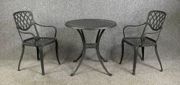 A 19th century style metal garden table and a matching pair of armchairs. Dia.75cm