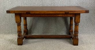 A Titchmarsh and Goodwin 20th century oak draw leaf extending refectory style dining table in the
