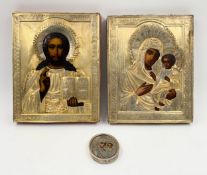 Two religious icons, hand painted on panel with silver oklads with engraved cyrillic text along with