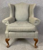 A Georgian style wing back armchair. H.103 W.85 D.73cm