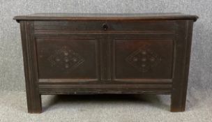 An 18th century country oak carved panelled coffer on stile supports. H.60 W.107 D.45cm