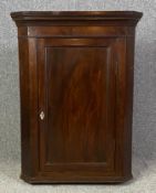 A Georgian mahogany hanging corner cabinet. H.97 W.73 D.43cm