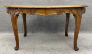 A French carved oak extending dining table with parquetry top and five extra temporary leaves. H.