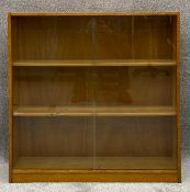 A mid century light oak book case with sliding plate glass doors by Phoenix of Charing Cross with