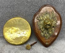 An intricately cast brass plaque depicting a tiger and a snake in foliage, supporting a polished