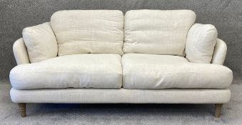 A contemporary oatmeal upholstered Loaf sofa with turned and limed oak feet and feather cushions.