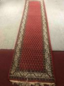 A 20th century Saraband runner on a burgundy field. L.350 W.86cm.