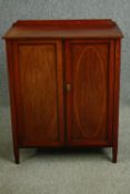 An Edwardian Sheraton revival mahogany and string inlaid music cabinet, circa 1910. H.95 W.76 D.