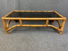 A vintage bamboo coffee table with smoked plate glass top. H.38 W.120 D.59cm