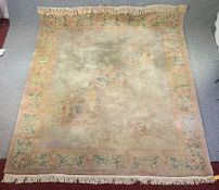 A large woollen carpet with allover Chinese motifs on a taupe field within stylised borders,