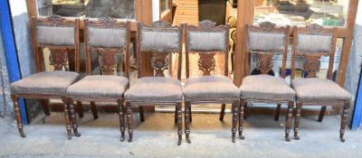 A set of six late 19th century carved walnut framed dining chairs.