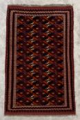 A hand woven Turkoman carpet with repeating serrated palm motifs across the field within stylised