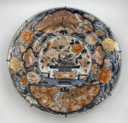 A large Japanese late 17th or early 18th century Edo period charger, decorated in iron-red, green