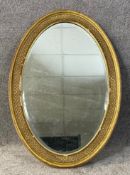 A C.1900 gilt gesso oval mirror with a bevelled plate. H.98 W.68cm