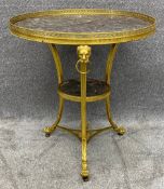 A French gilt metal gueridon or lamp table in the neoclassical style with a marble top above lion'