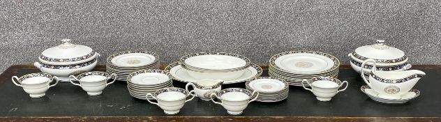 A Wedgwood hand enamelled bone china dinner service with classical motifs. Eight dinner plates