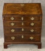 A Georgian mahogany bureau with brass handles raised on bracket feet. H.102 W.84 D.49cm