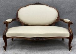 A Victorian carved walnut frame sofa reupholstered in piped calico. H.98 W.139 D.72cm