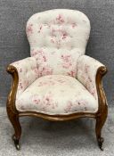 A Victorian mahogany armchair reupholstered in a buttoned and piped flowerhead calico. H.96 W.69 D.