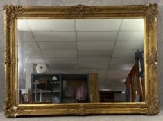 A large C.1900 carved giltwood and gesso mirror with scrolling foliate decoration. H.253 W.182cm