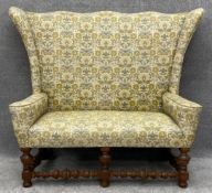 A Jacobean style high back sofa with bobbin turned oak supports in needlework upholstery. H.128 W.