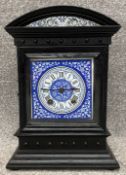 A 19th century aesthetic movement ebonised oak mantel clock with a blue and white enamelled dial and
