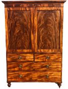 A Regency two section flame mahogany linen press fitted with hanging rail raised on squat turned