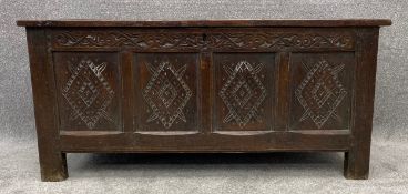 An 18th century oak coffer with carved panels on stile supports. H.67 W.145 D.62cm