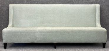 A large contemporary sofa/settle in green patterned upholstery, on stained oak legs. H.110 W.251 D.