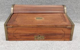 A 19th century mahogany and brass bound military writing slope with tambour top enclosing pen