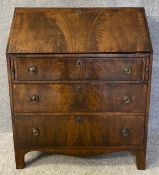 A Georgian flame mahogany writing bureau with ebony inlay and a fitted interior. (Fall front