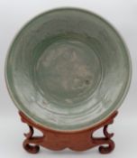 A large Song dynasty (960-1279) style Chinese bowl with a celadon crackle glaze, on a hardwood