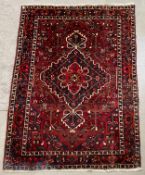 A hand knotted Shiraz carpet with central medallions and stylised flowerhead motifs across the