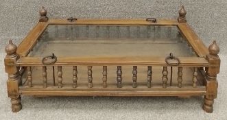 An Eastern hardwood coffee table with iron and brass fittings and a plate glass top. H.31 W.86 D.