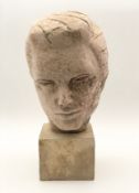 A mid century modernist style carved composite stone bust of a young male, on a square plinth. H.