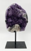 An amethyst geode on a museum style stand.H.29cm