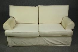 A two seater sofa in ivory upholstery. H.96 W.183 D.95cm.