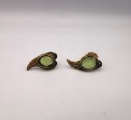 A pair of modern 9ct yellow gold and peridot stylised leaf stud earrings, each earring set with an