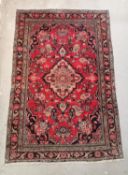 A Bidjar rug with central medallion on a burgundy ground with flowerhead decoration within