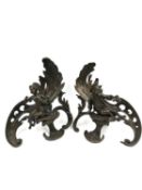 A pair of bronze free standing chenets depicting a seated boy and girl atop a plinth against a