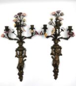 A pair of French bronze wall sconces; Cherubs/Putti supporting four branches terminating in