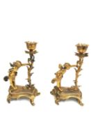A pair of Rococo style ormolu candelabras depicting fairies with butterfly wings holding up