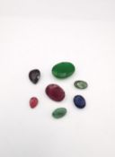 Seven gem stones to include a ruby, an emerald, a garnet and a sapphire (largest stone possibly