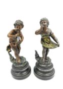 A pair of French cold painted spelter figures, cupid playing pipes and a girl curtsying. both with