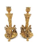 A pair of ormolu candelabras depicting three musical putti/cherubs with lute, flute and song sheet