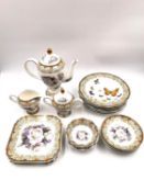 A matched part tea service to include six saucers, six square plates, a teapot, creamer and sugar