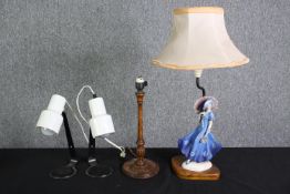 A Doulton style figural table lamp, two white painted metal reading lamps and a turned wooden lamp