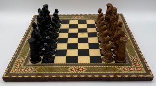 A medieval themed resin chess set with a printed board. King H.10cm, Board W.40 D.40cm