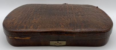 An early 20th century manicure set in a fitted crocodile skin case. W.35cm