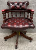 A 19th century style mahogany framed captain's chair with swivel and reclining action upholstered in